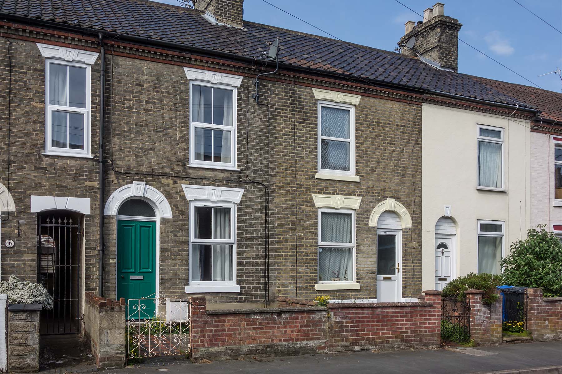 Grey brick terrace with green front door