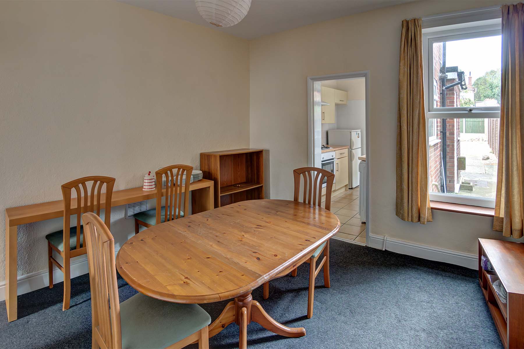 Dining room with dining table set, leading to kitchen