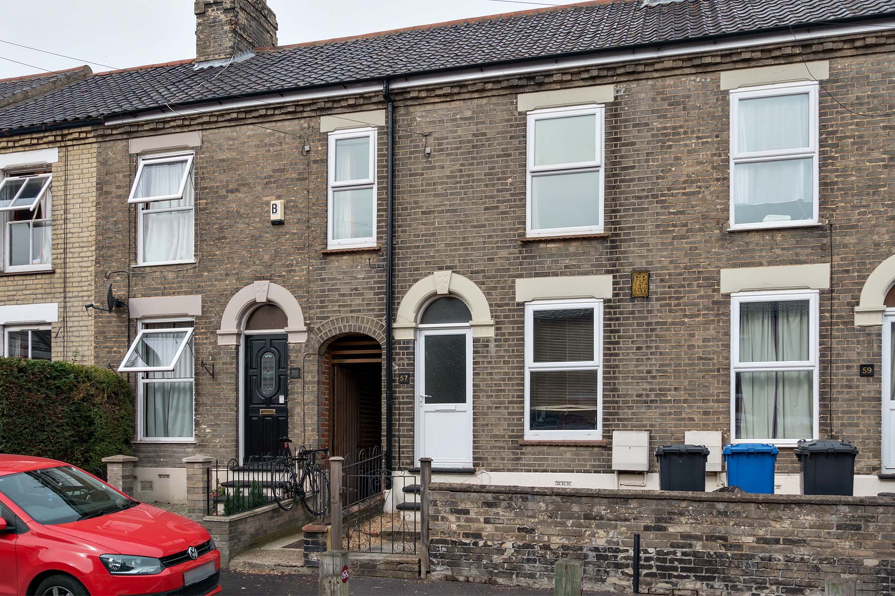Grey terraced house with white front door and side access