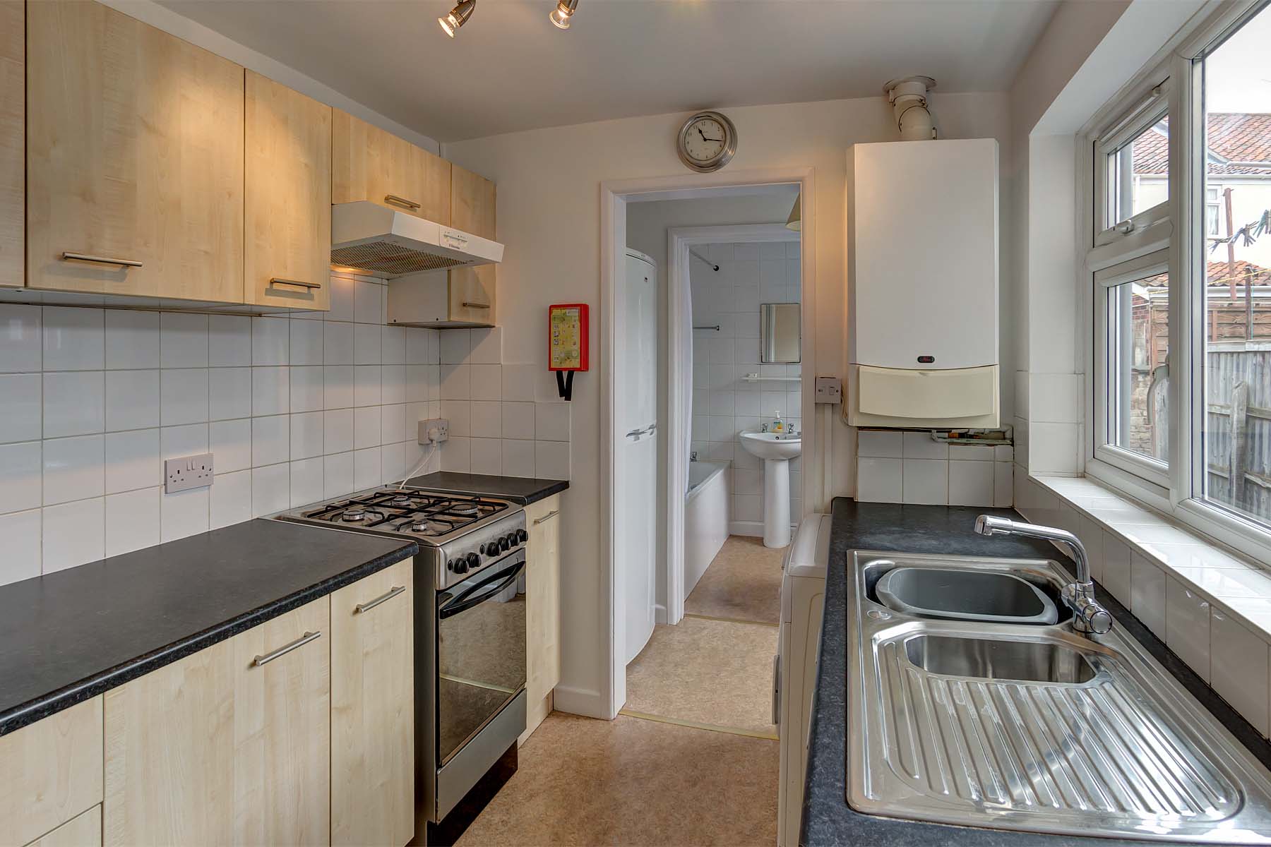 Galley style kitchen with fitted wooden look units.