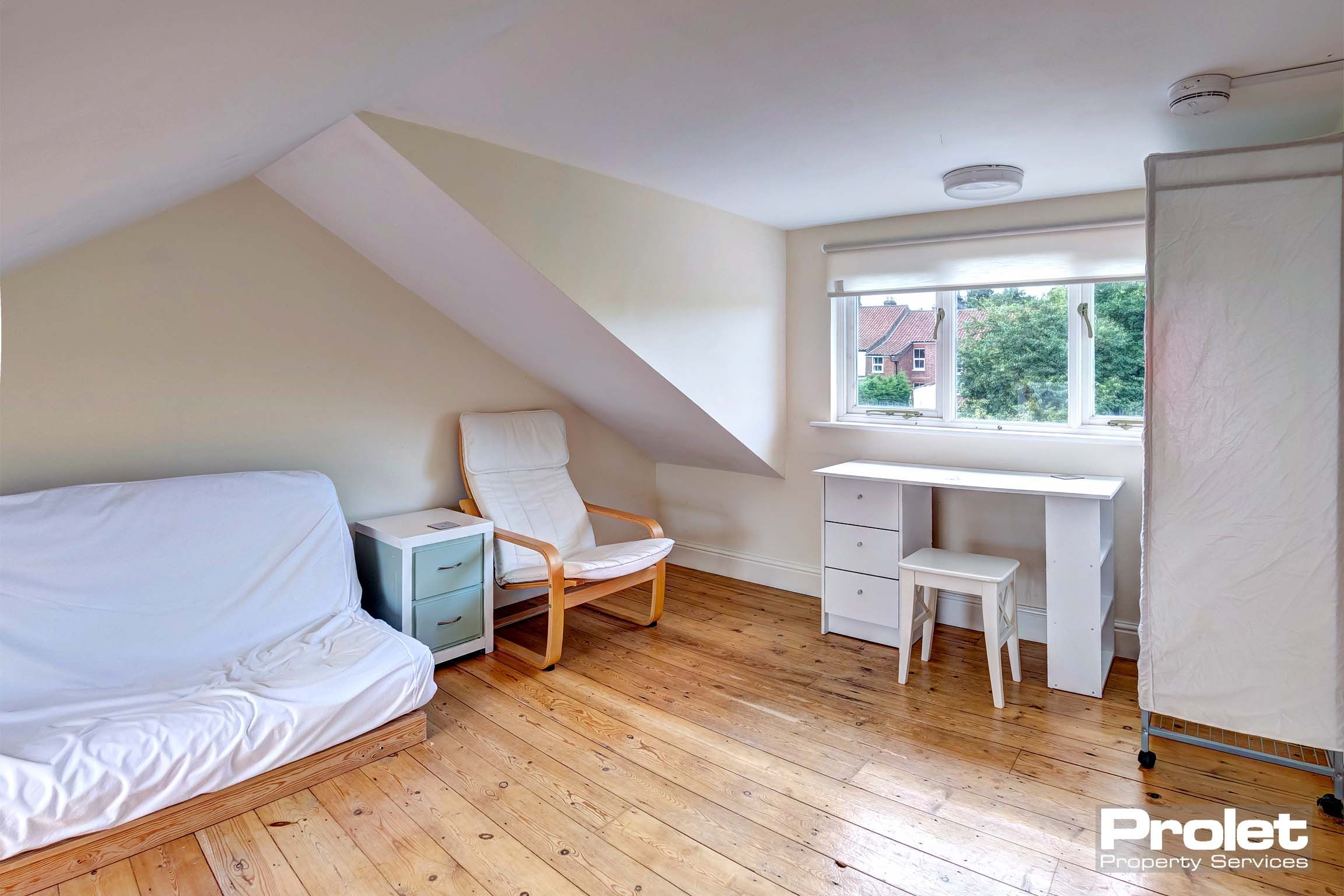 Attic room with wooden floor and white furnishings