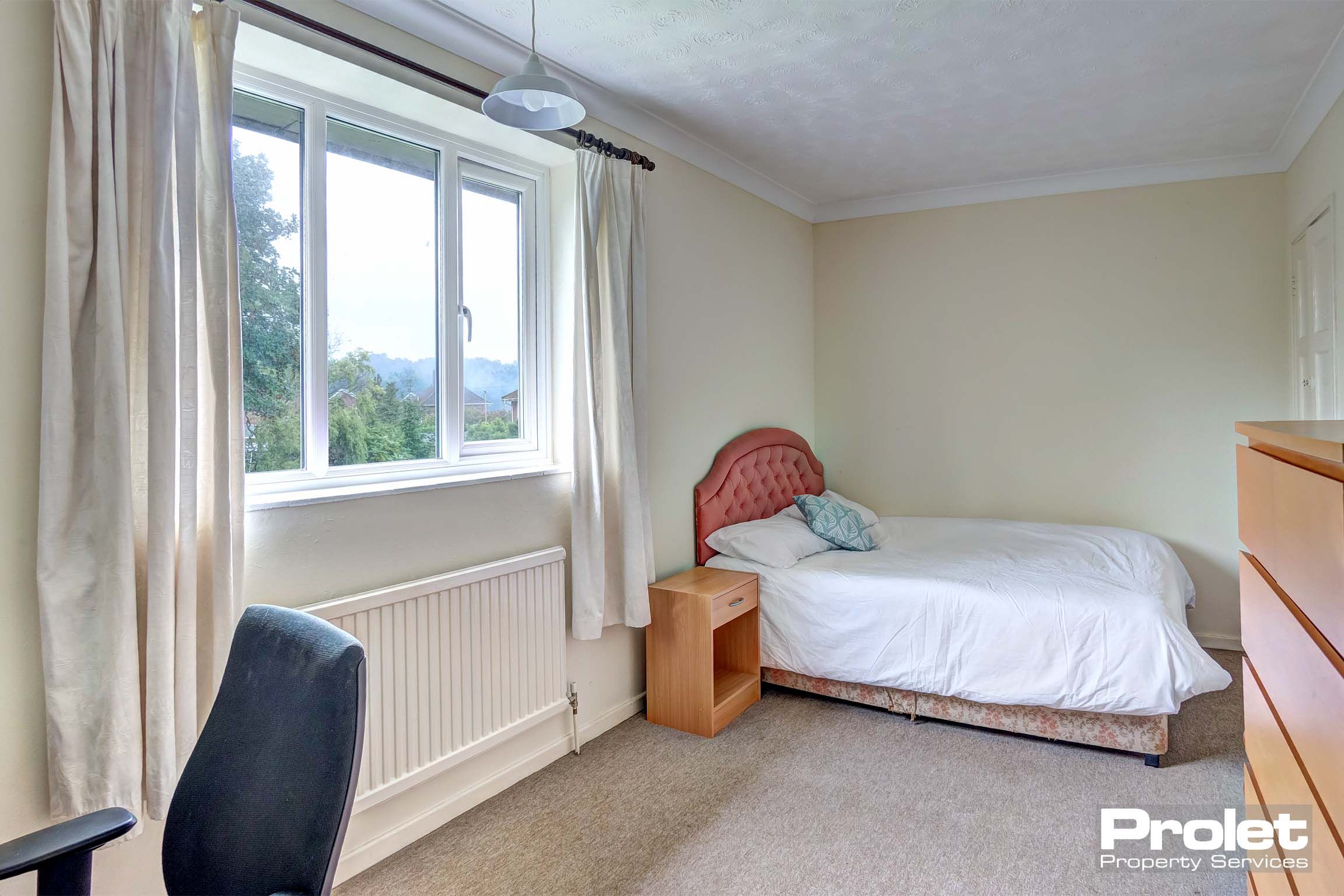 Double bedroom with cream carpet and bed