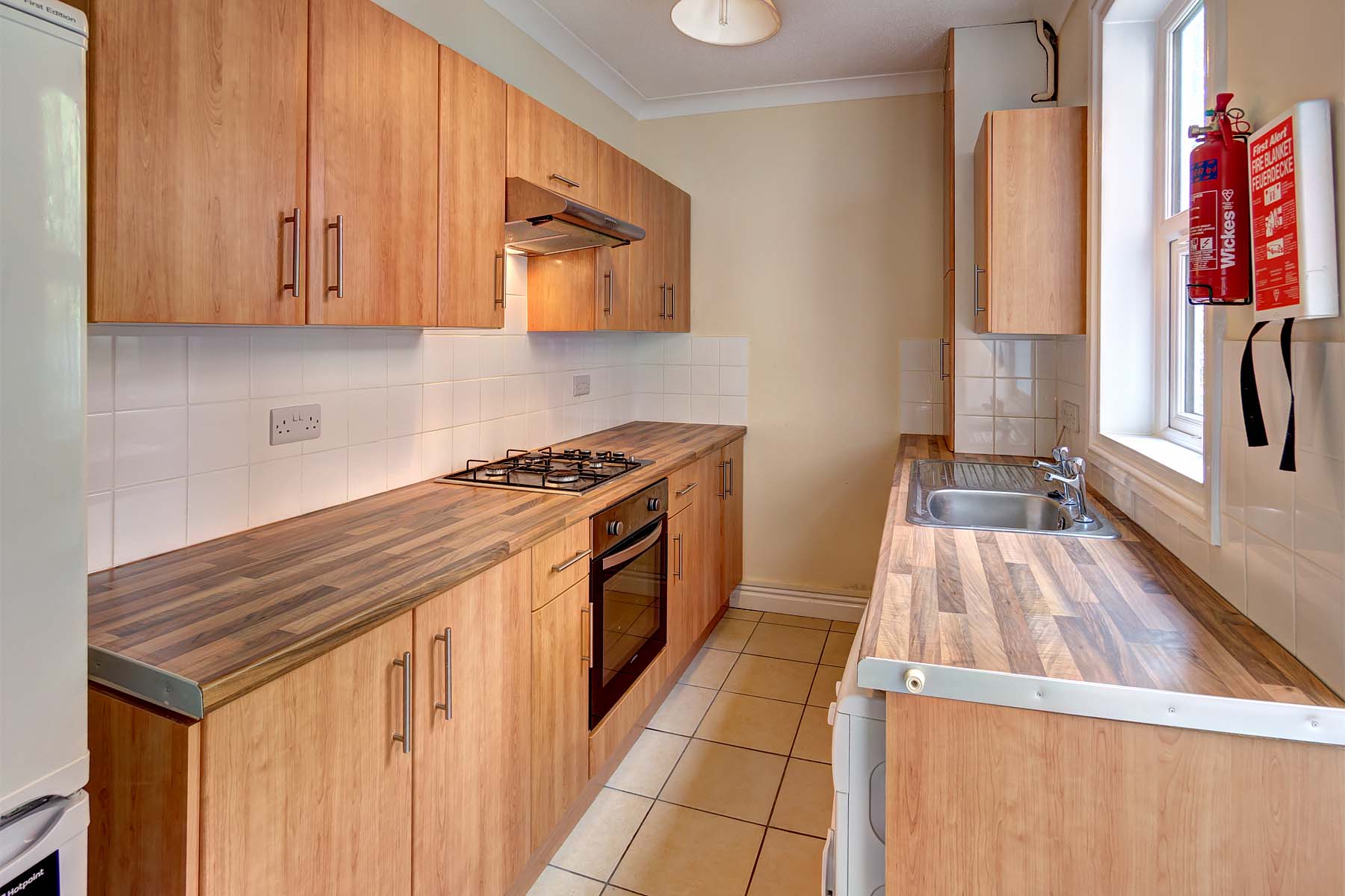 Galley kitchen with wood effect cabinets and worktop