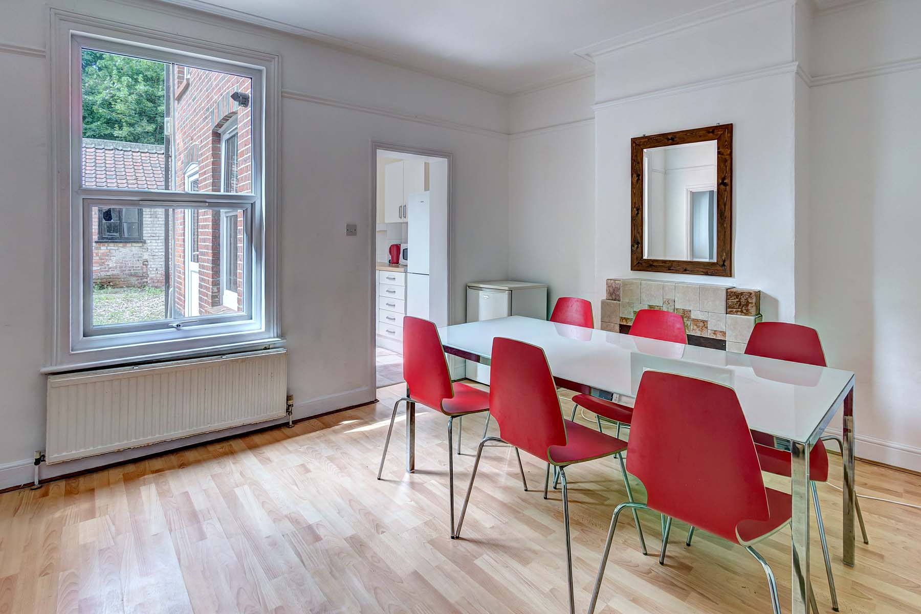 Dining room with white dining table and red chairs