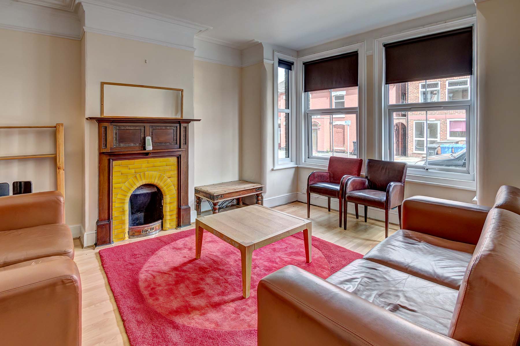 Large living room with sofa, and period fireplace.