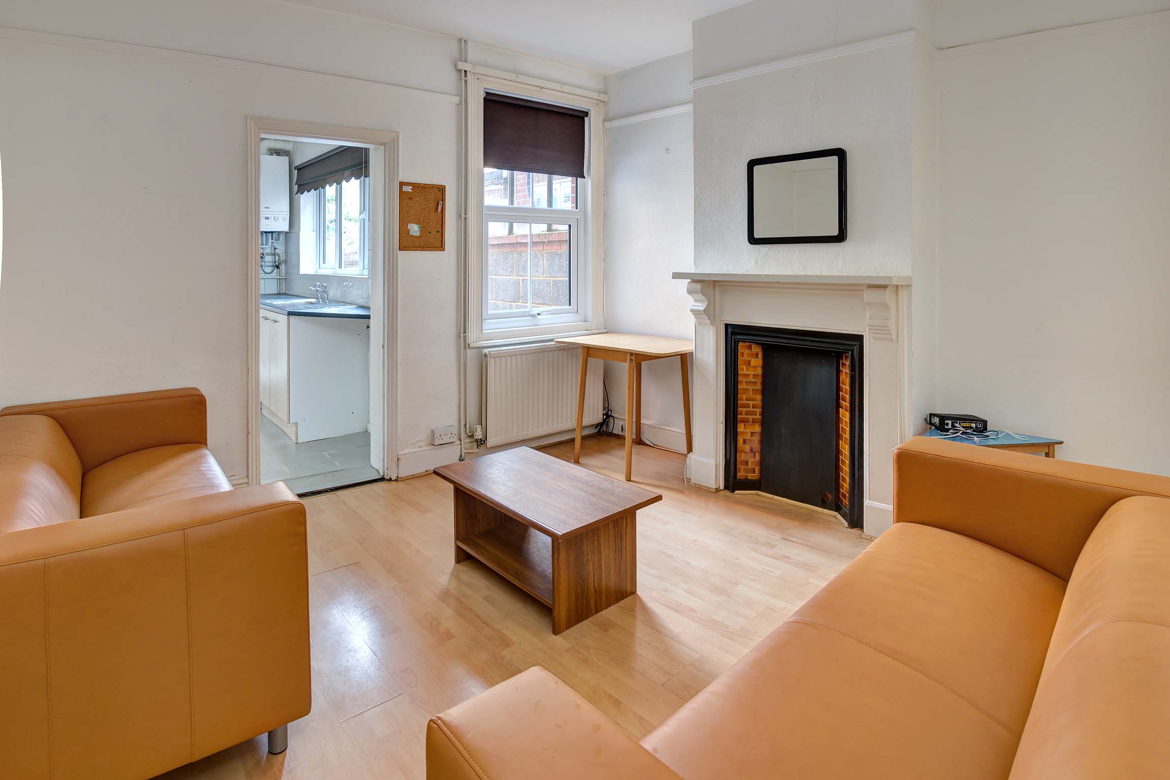 Lounge area with decorative fireplace and orange leather sofas.