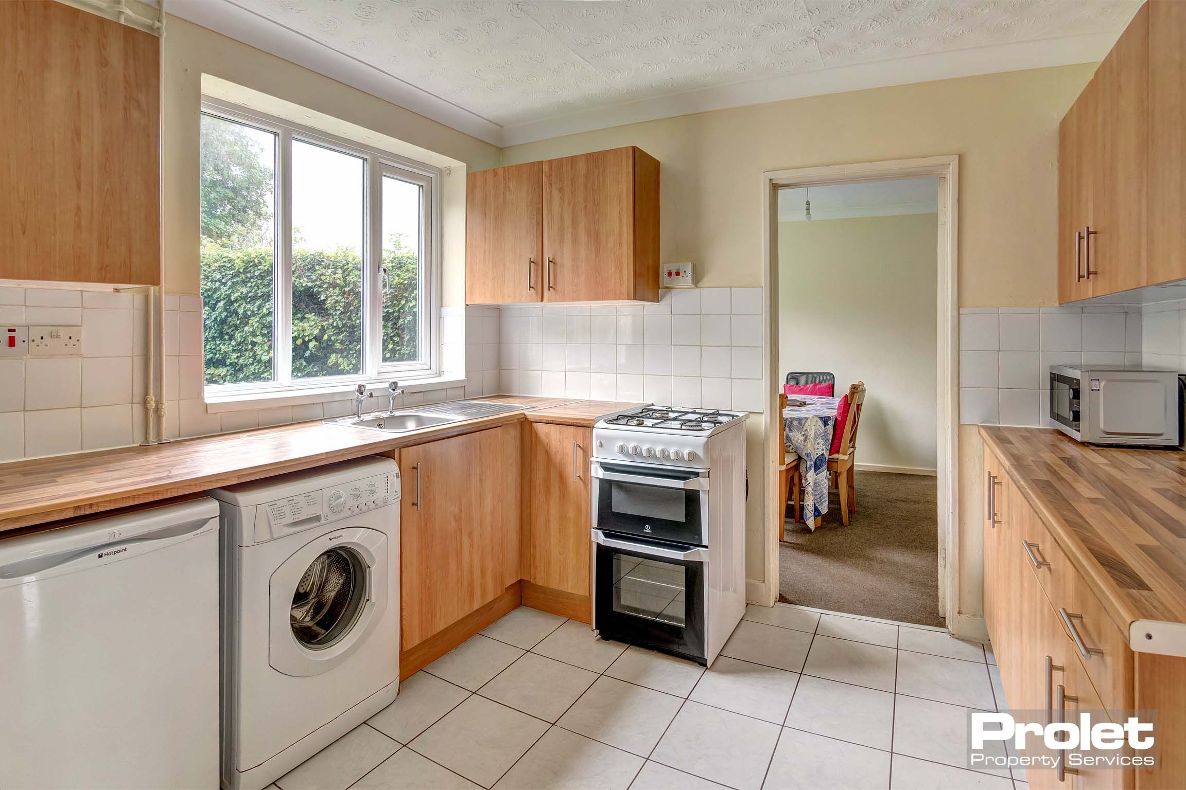 Kitchen with white tile floor and white goods