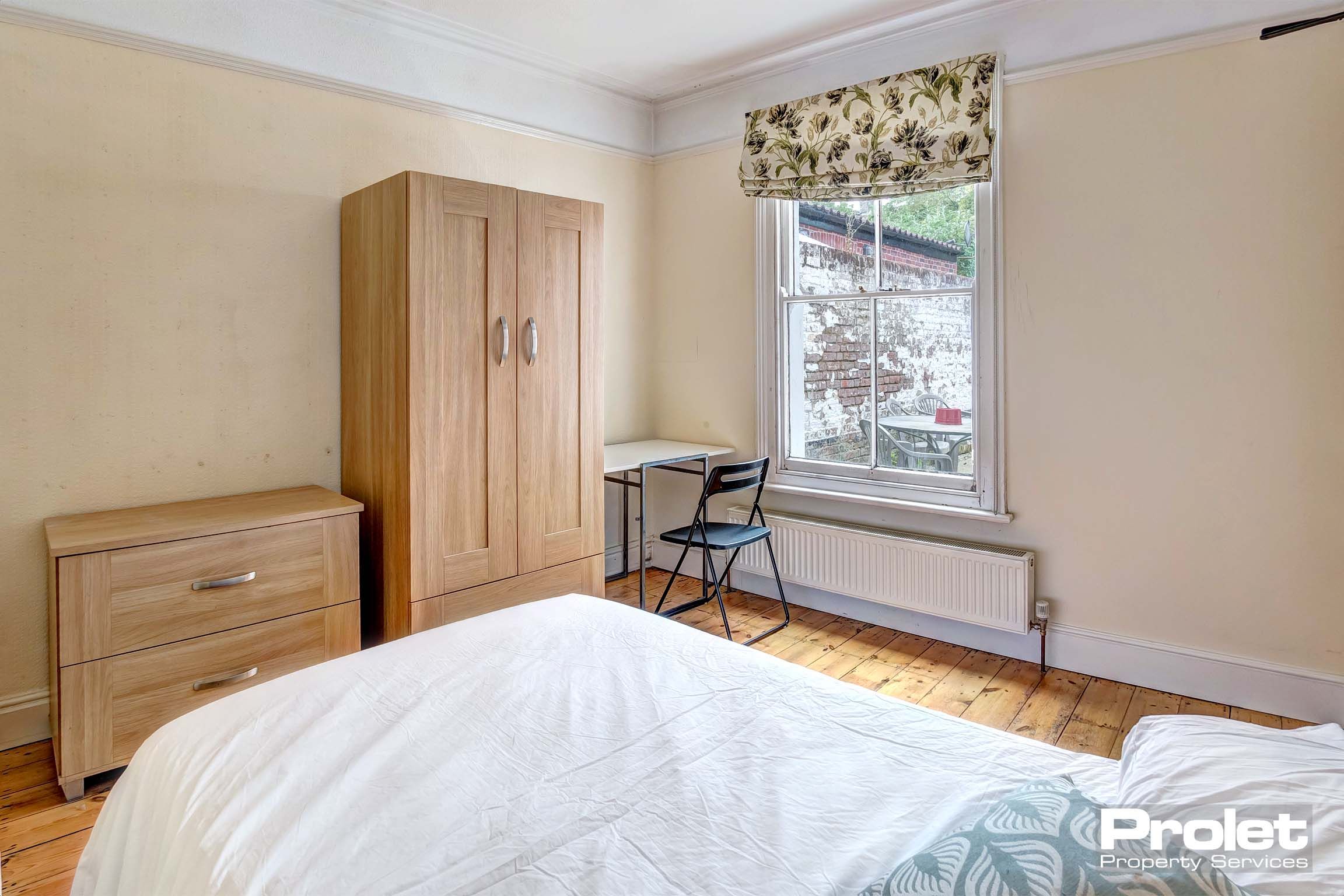 Large bedroom with double bed and wooden furnishings