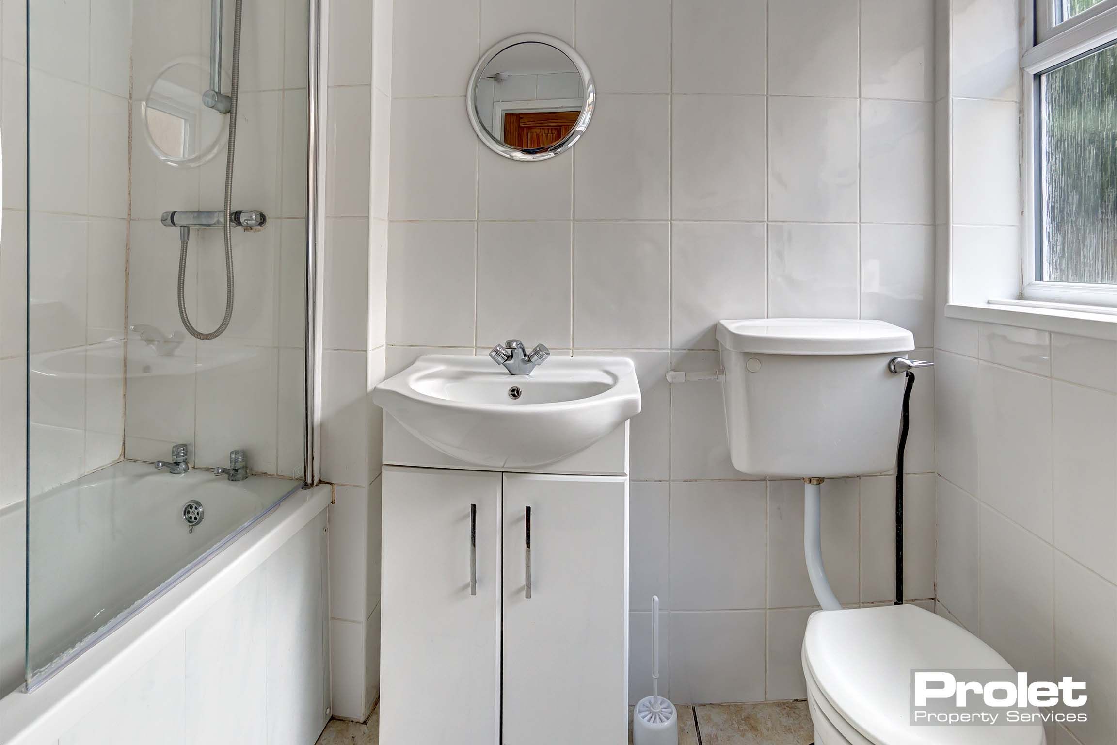 Bathroom with shower over bath, sink, and toilet
