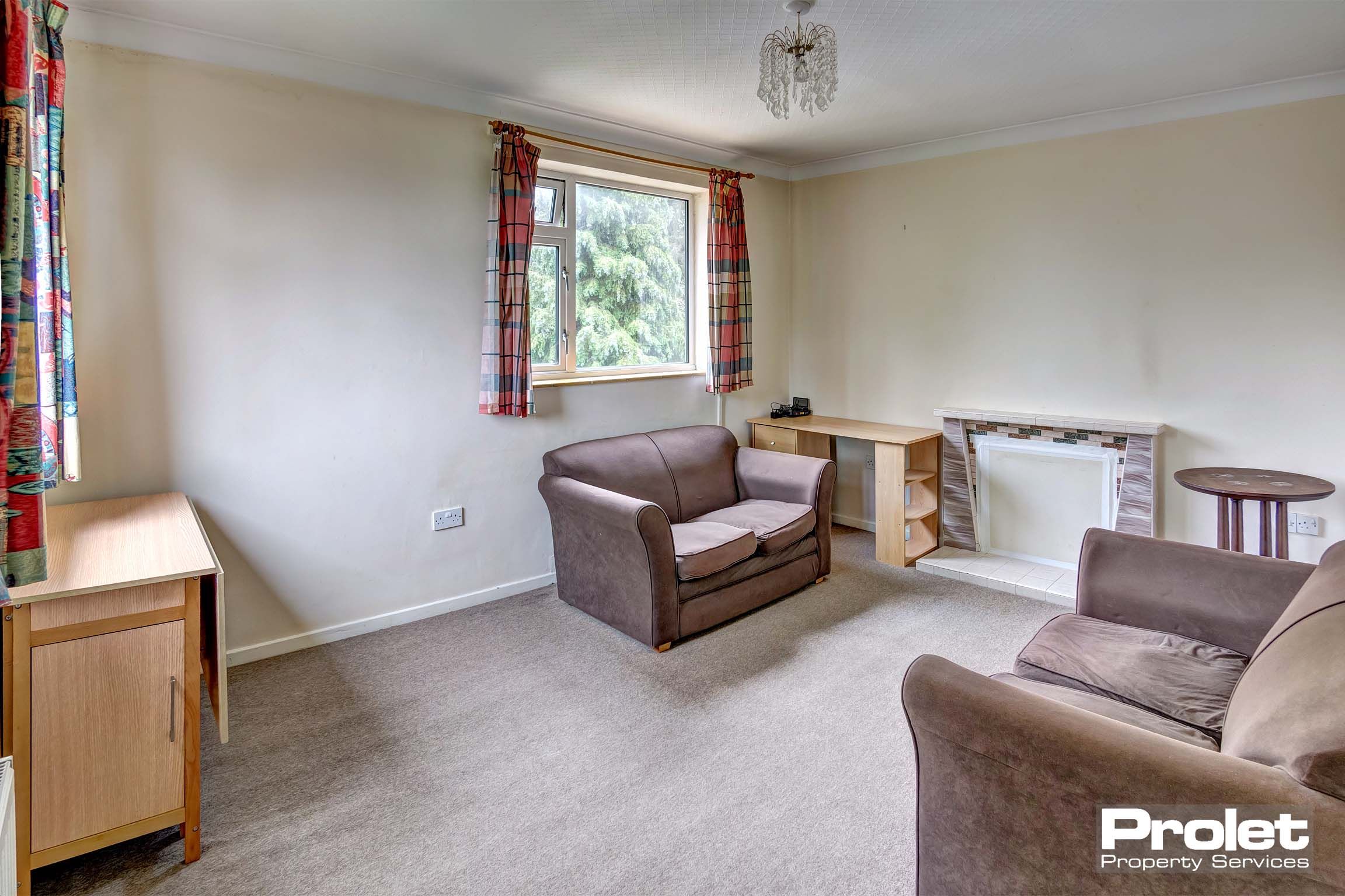 Large lounge with light coloured carpet and two brown sofas.