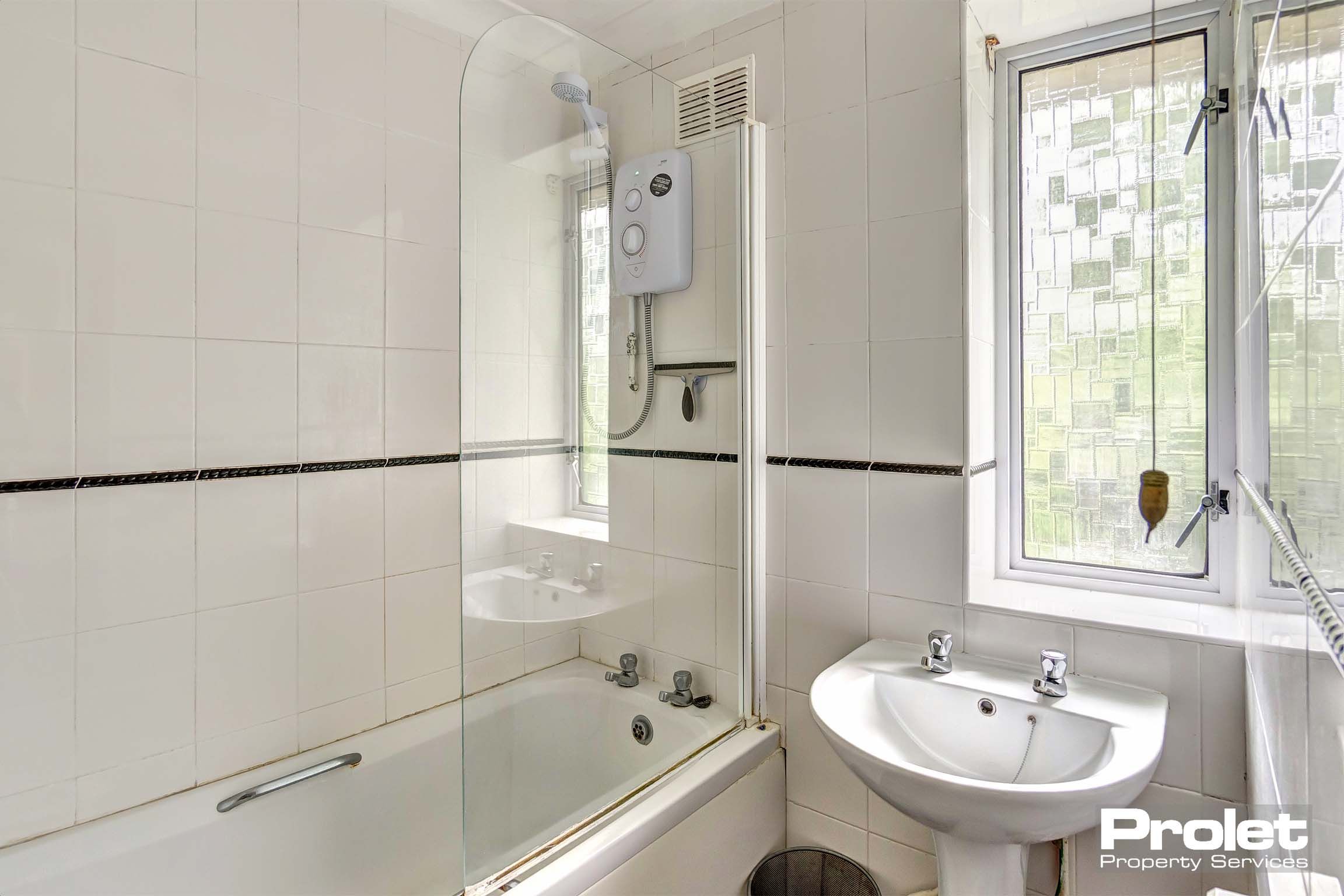 Bathroom with shower over the bath and sink