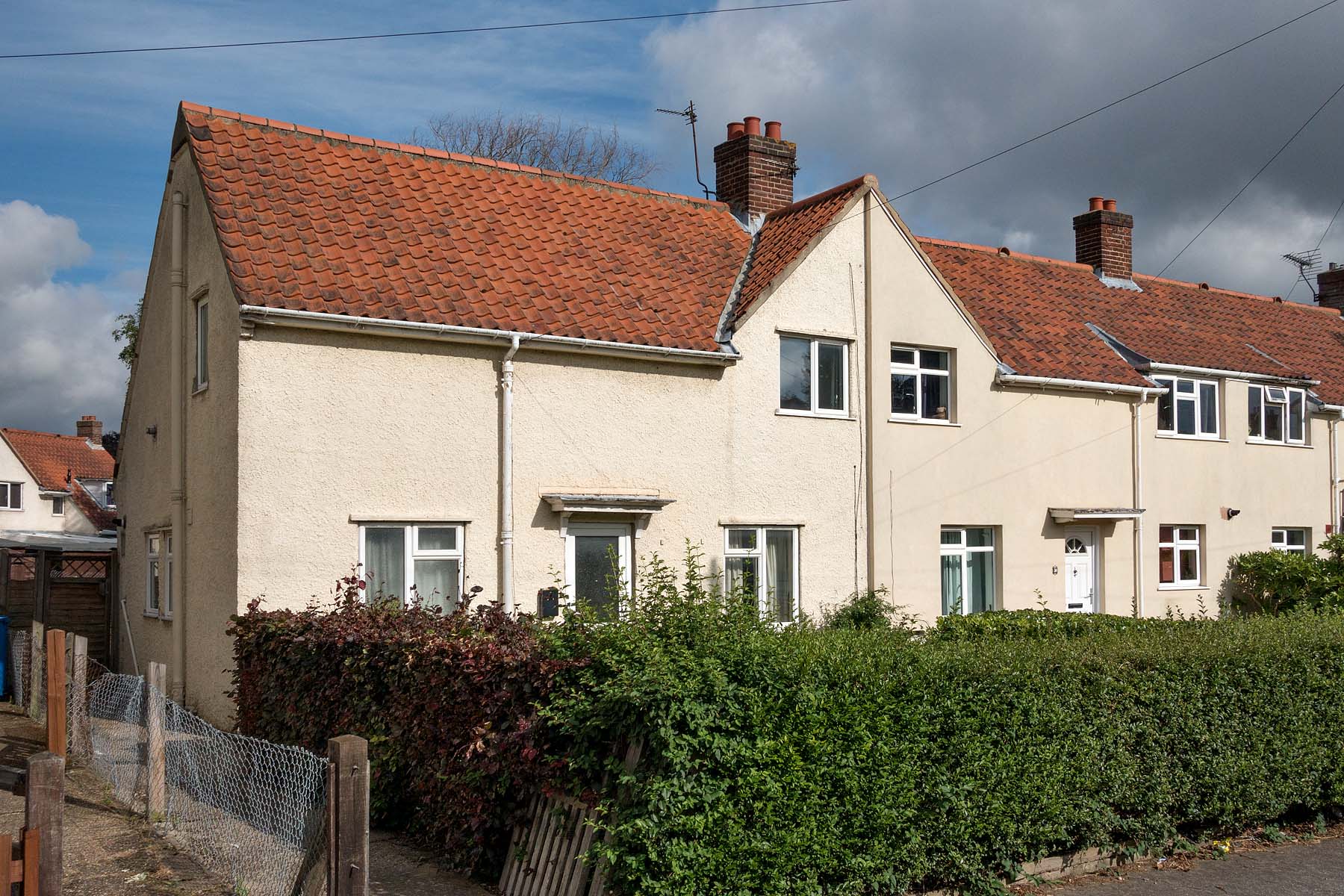 White painted semi-detached house with front hedging
