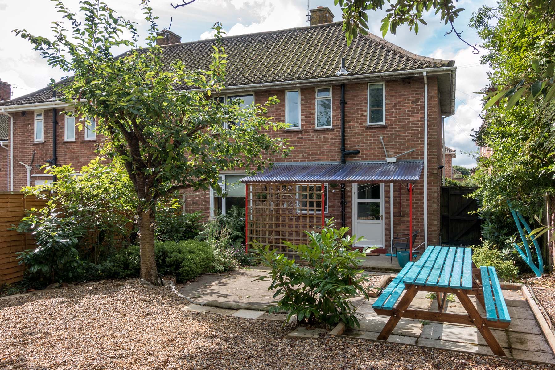 Rear view of brick house with wooden picnic bench