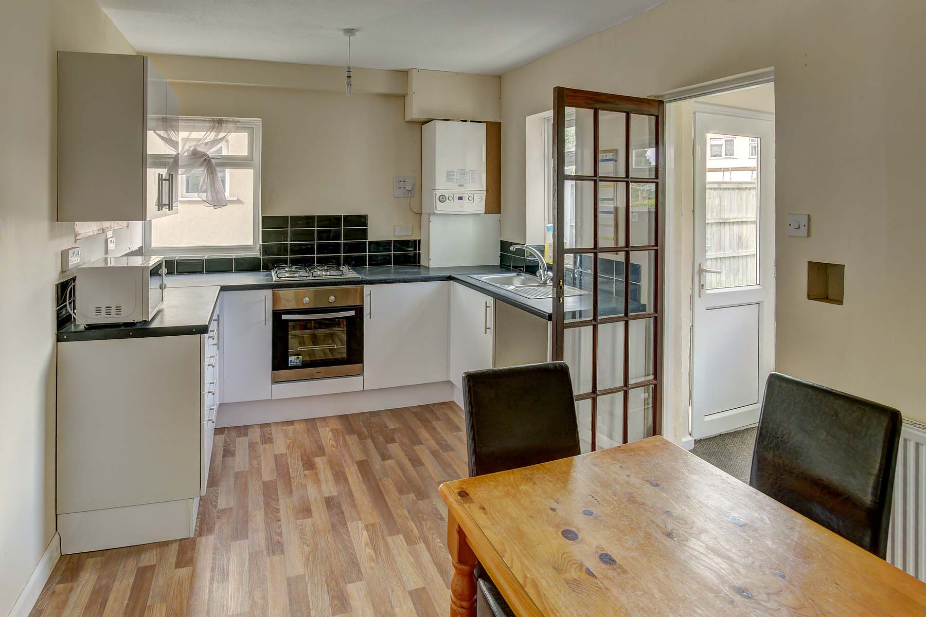 Large kitchen with white cabinets and dining set