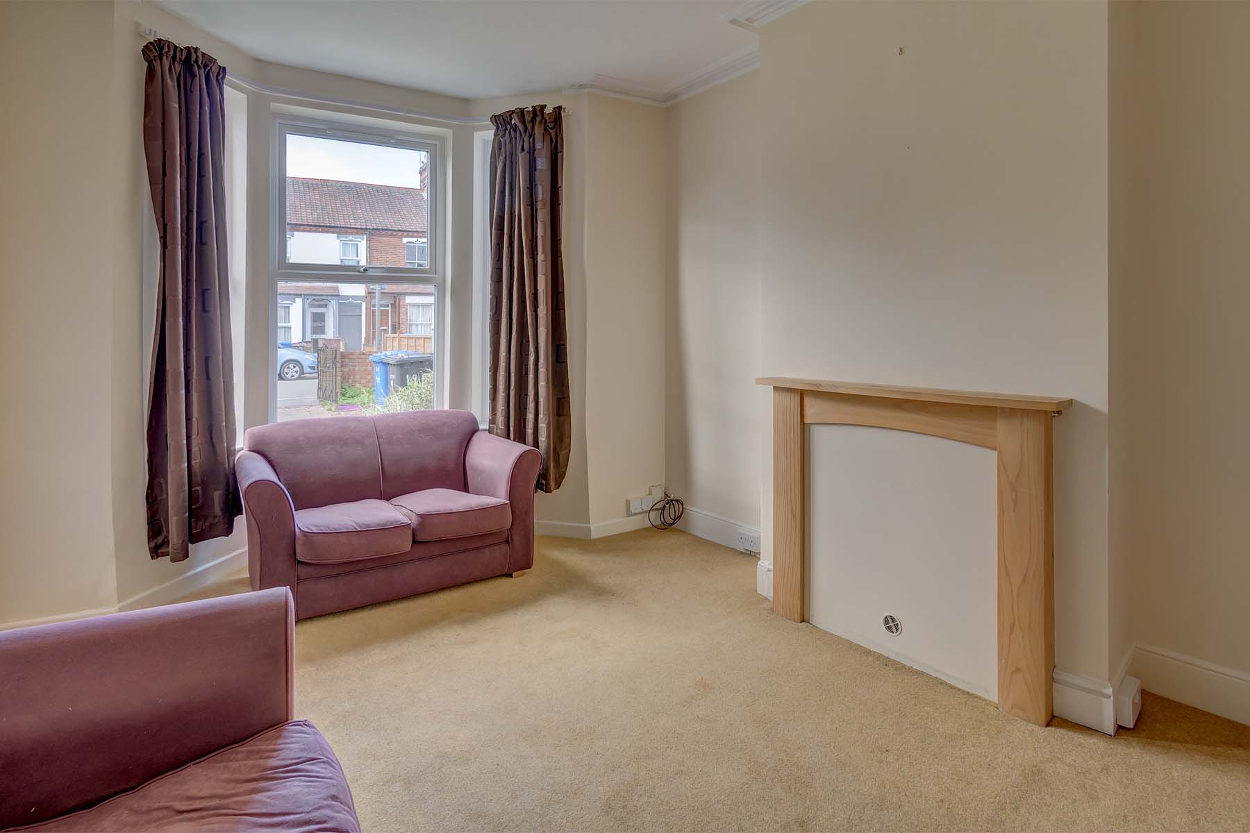 Large living room with sofas and a bay window