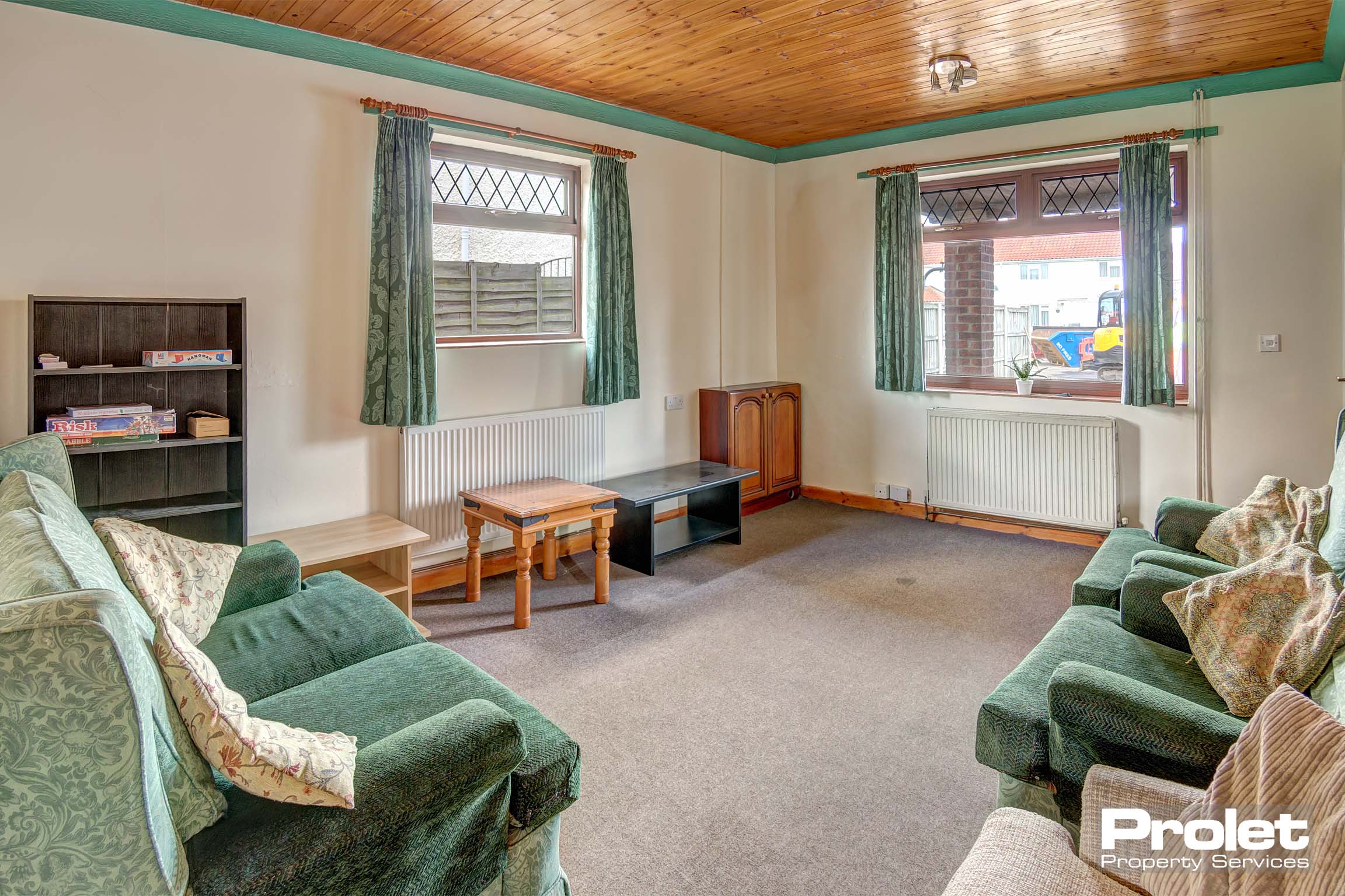Large living room with green sofas