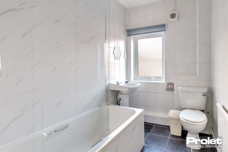 Upstairs family bathroom with shower over bath, toilet, and sink