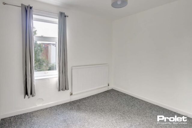Double bedroom with grey carpet and white walls