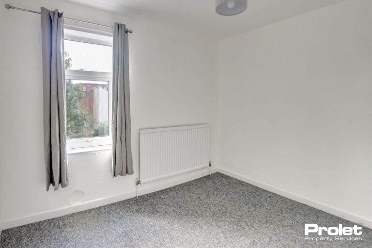 Double bedroom with grey carpet and white walls