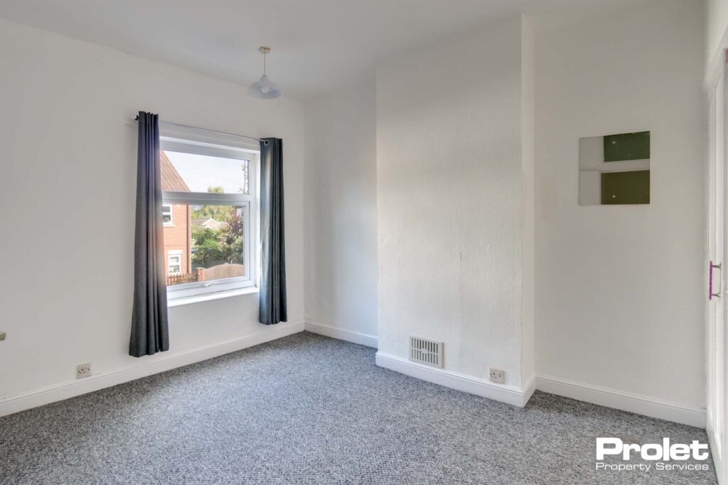 Double bedroom with grey carpet and white walls