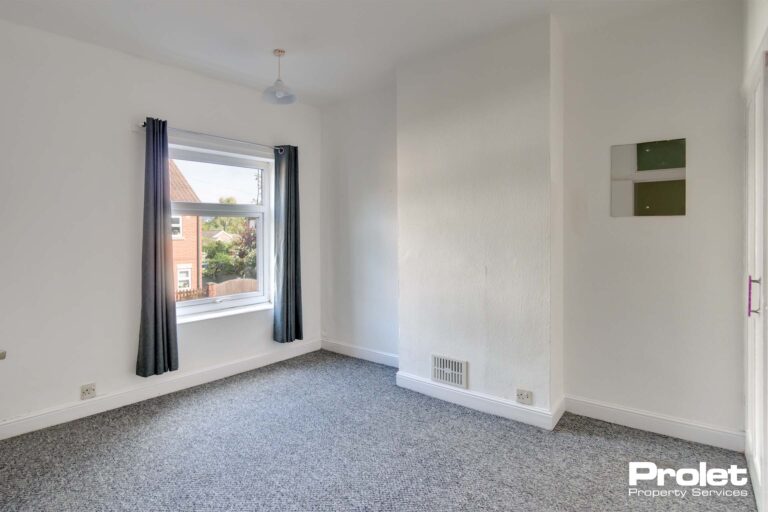 Double bedroom with grey carpet and white walls