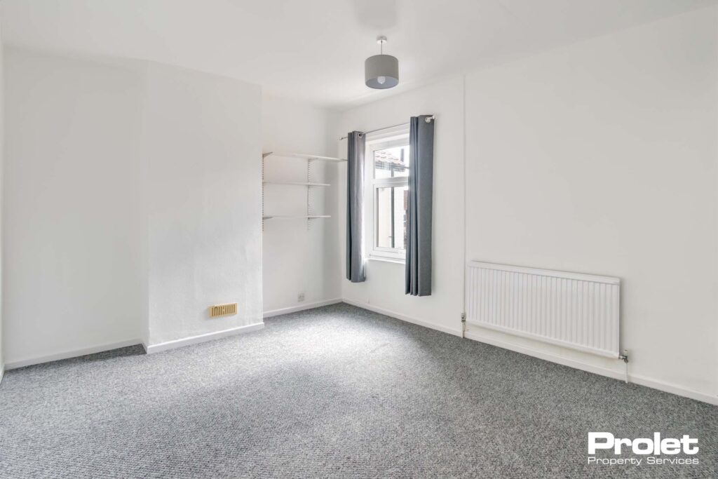 Double bedroom with grey carpet and white walls