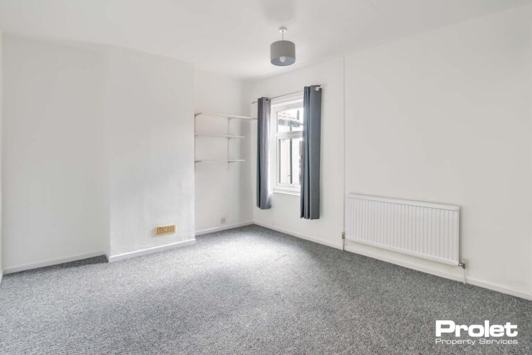 Double bedroom with grey carpet and white walls