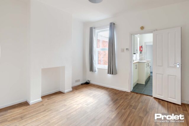 Dining area, whith wood effect laminate floor, white walls, leading to kitchen