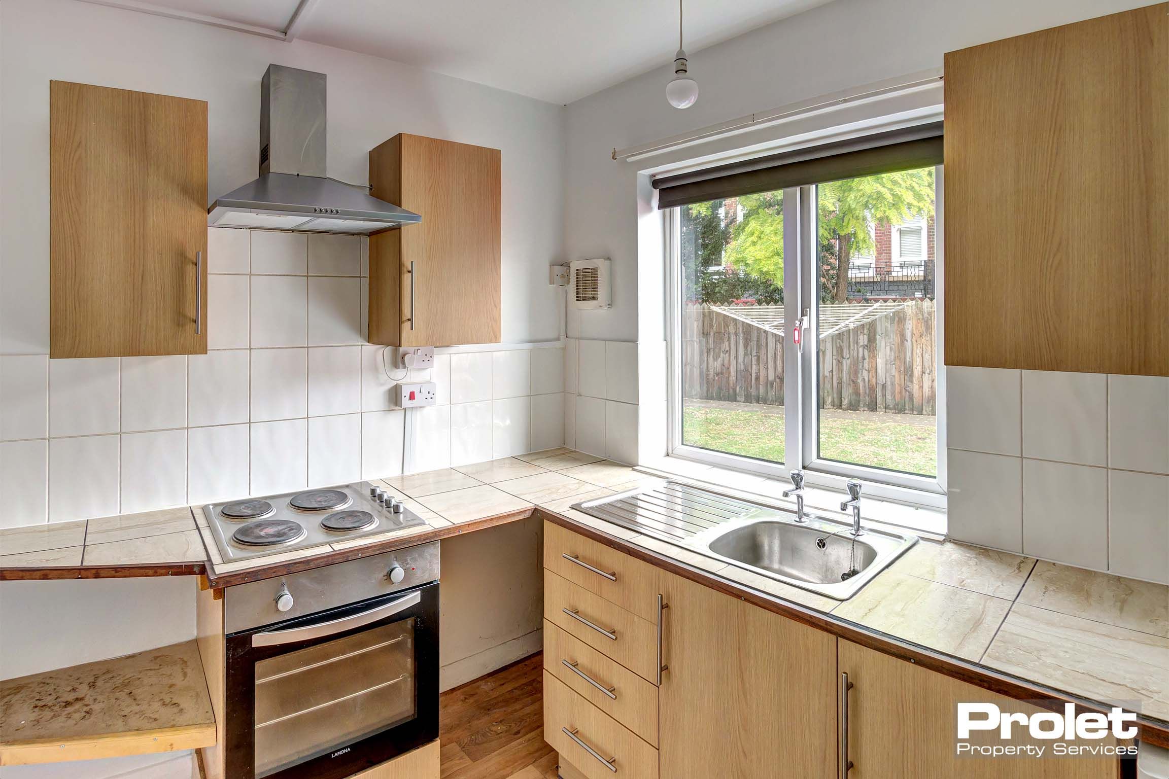 Kitchen with wood effect cabinets and white goods