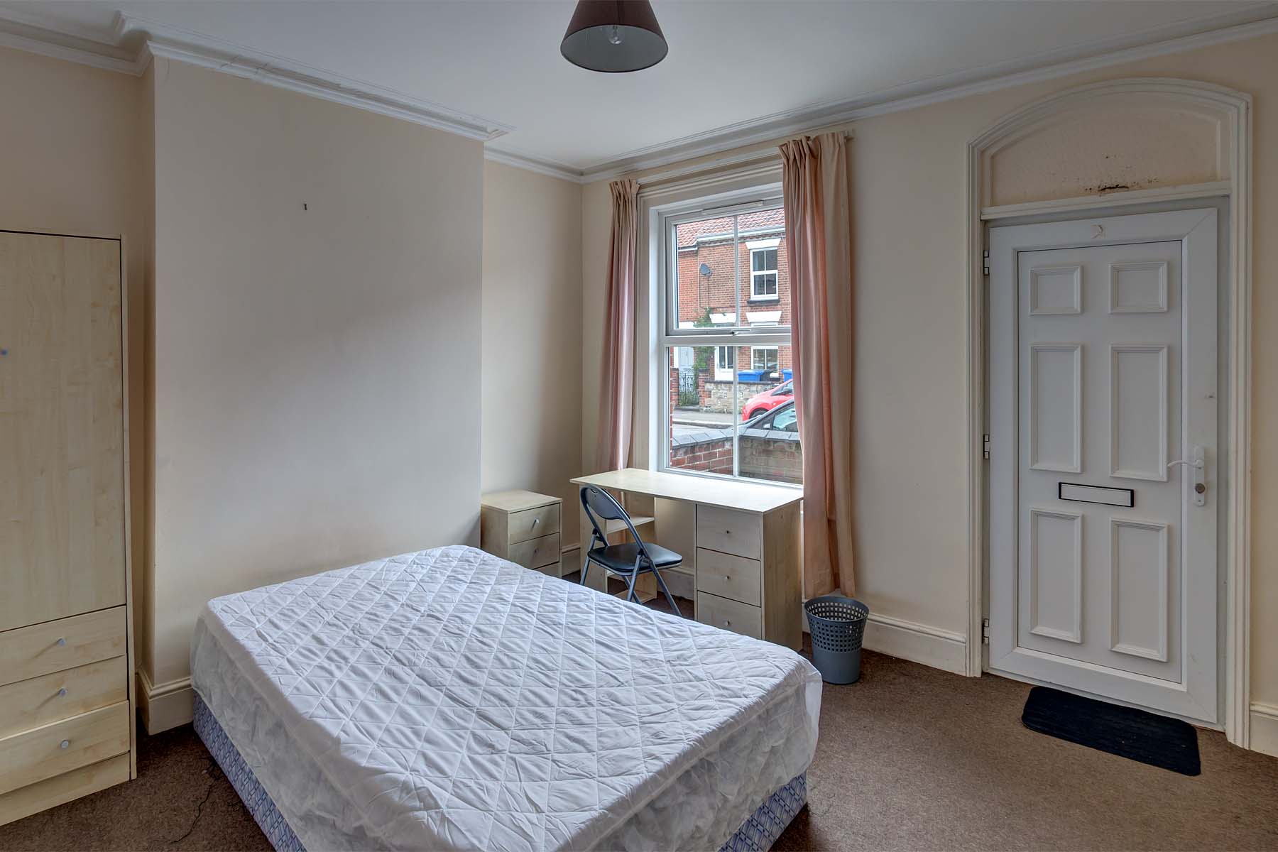 Downstairs bedroom with double bed, desk, and access to the front door