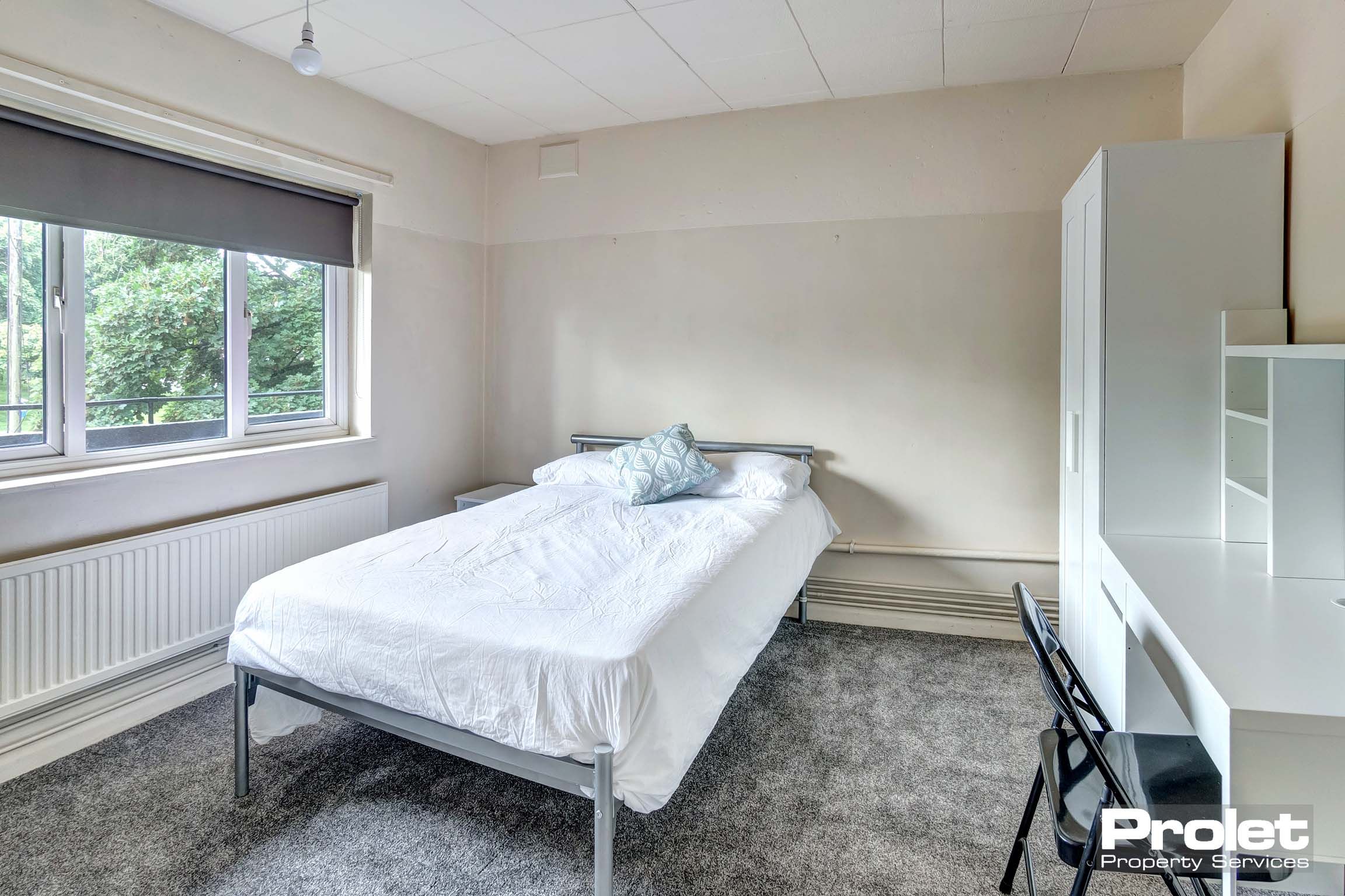 Bedroom with grey carpet, double bed, and white furnishings