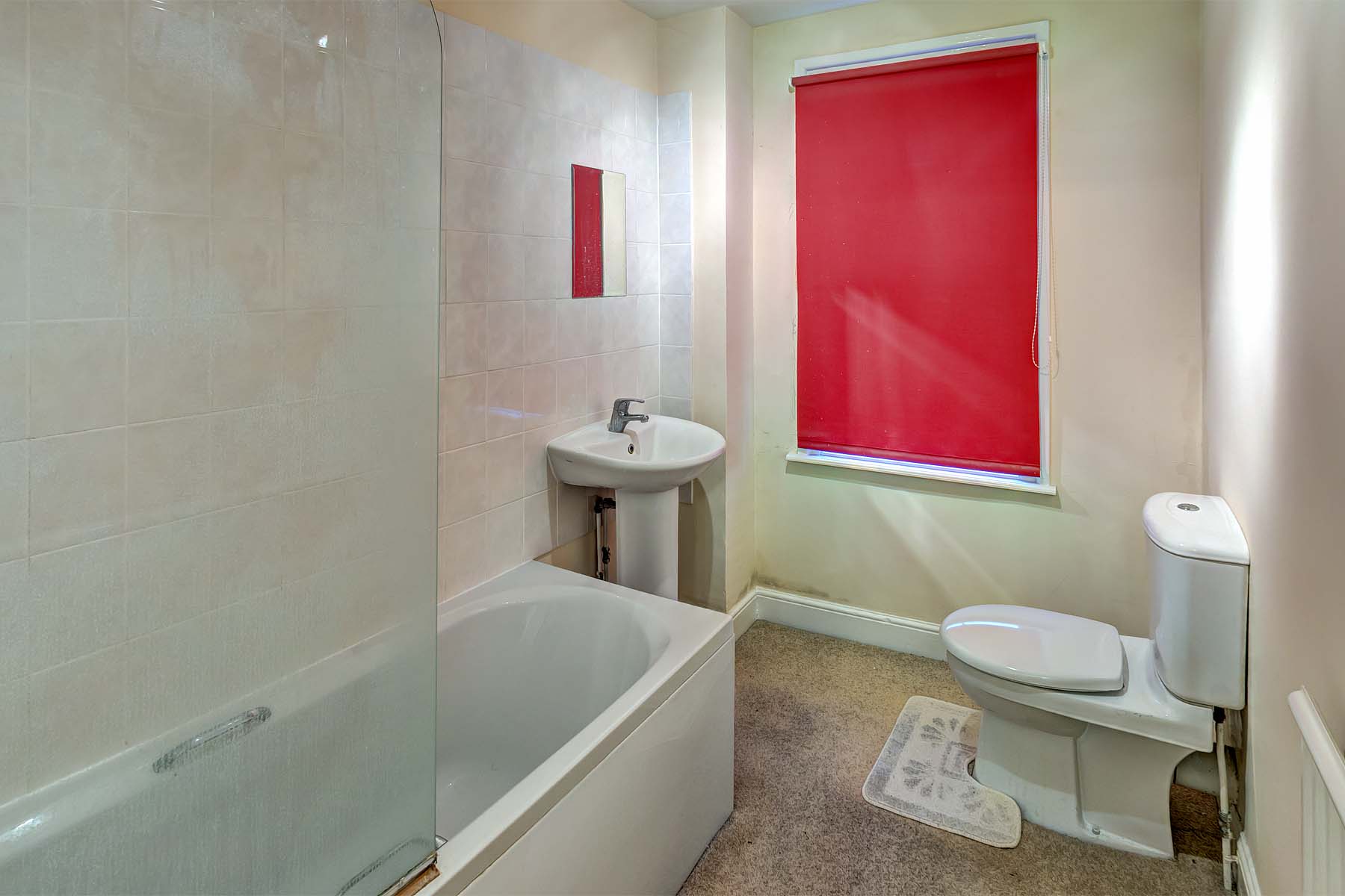 Magnolia walls with vinyl flooring and white bathroom suite with shower over bath