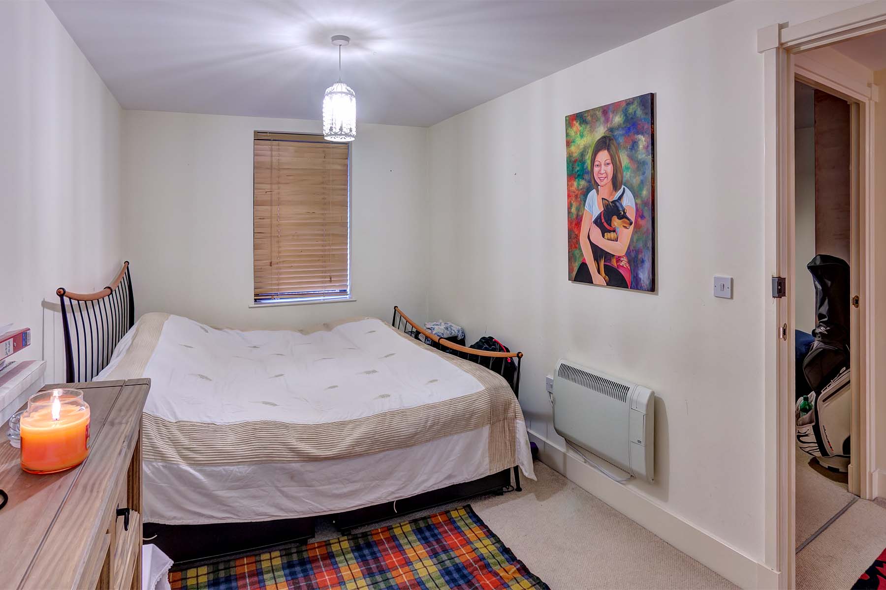 Furnished double bedroom with white walls and laminate flooring