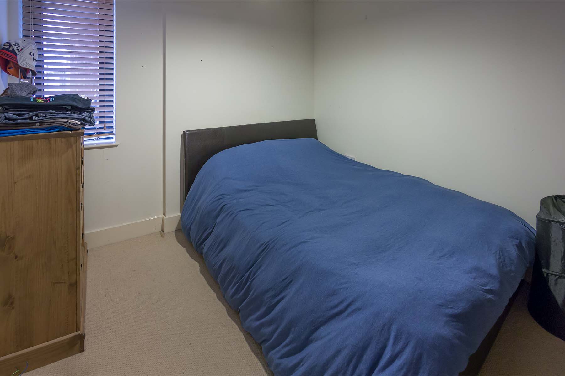 Furnished double bedroom with white walls and laminate flooring