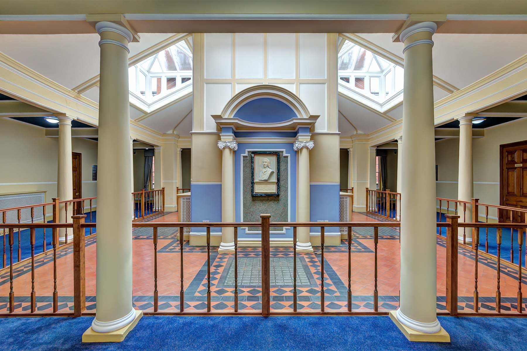 Large historic foyer with decorative columns leding off to three wings of the building