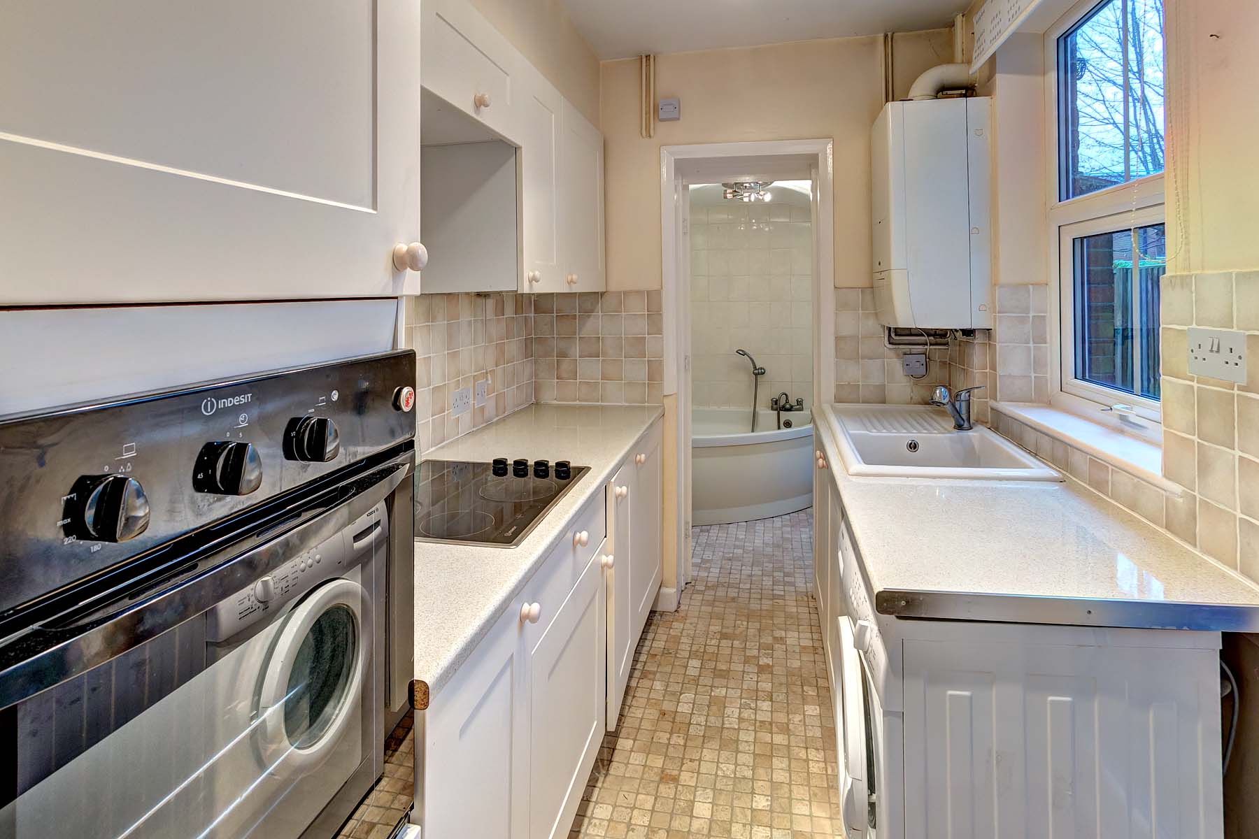 Magnolia walls with white kitchen suite, oven, washing machine and fridge freezer