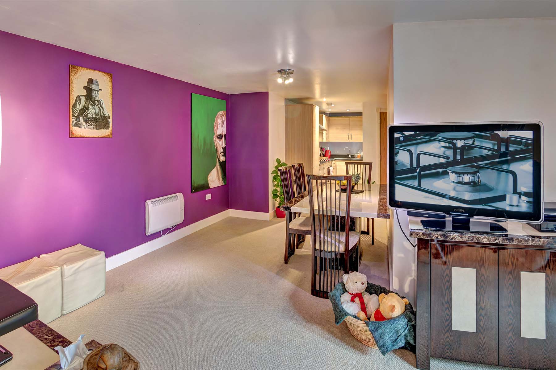 Large lounge/diner with cream carpets, purple painted wall and dining table