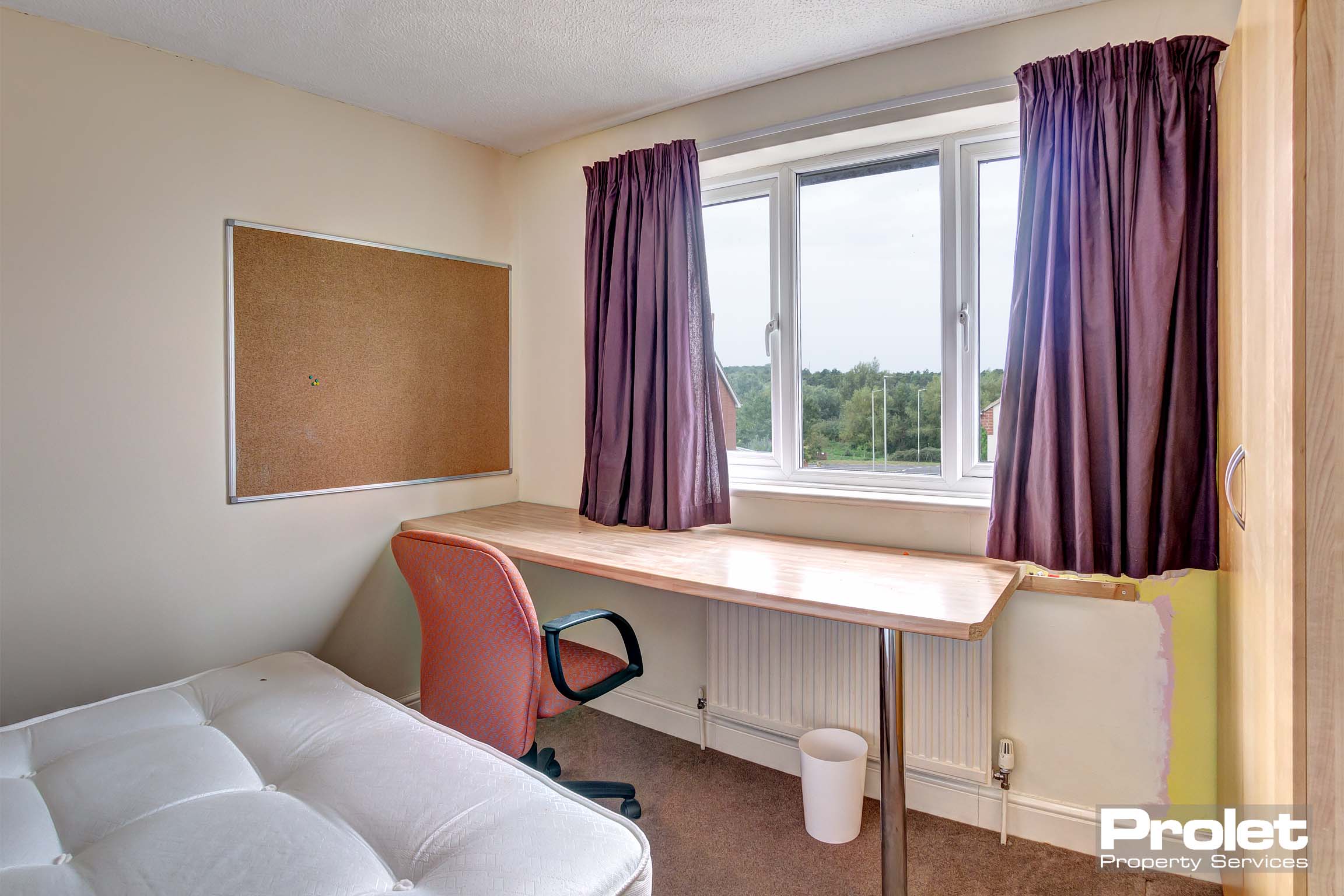Bedroom with large desks and corkboard