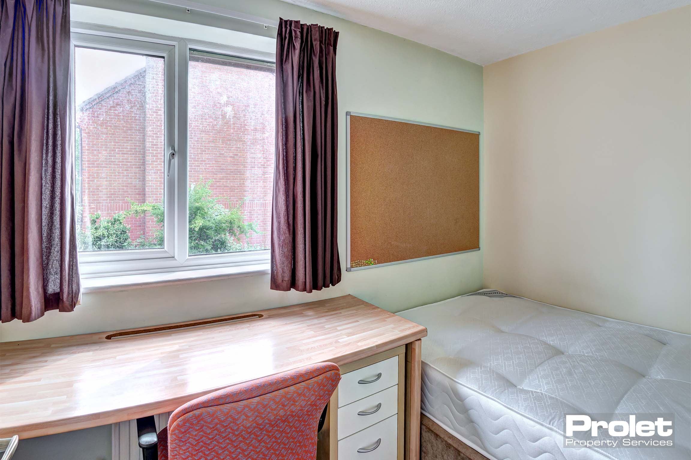 Bedroom with desks and corkboard