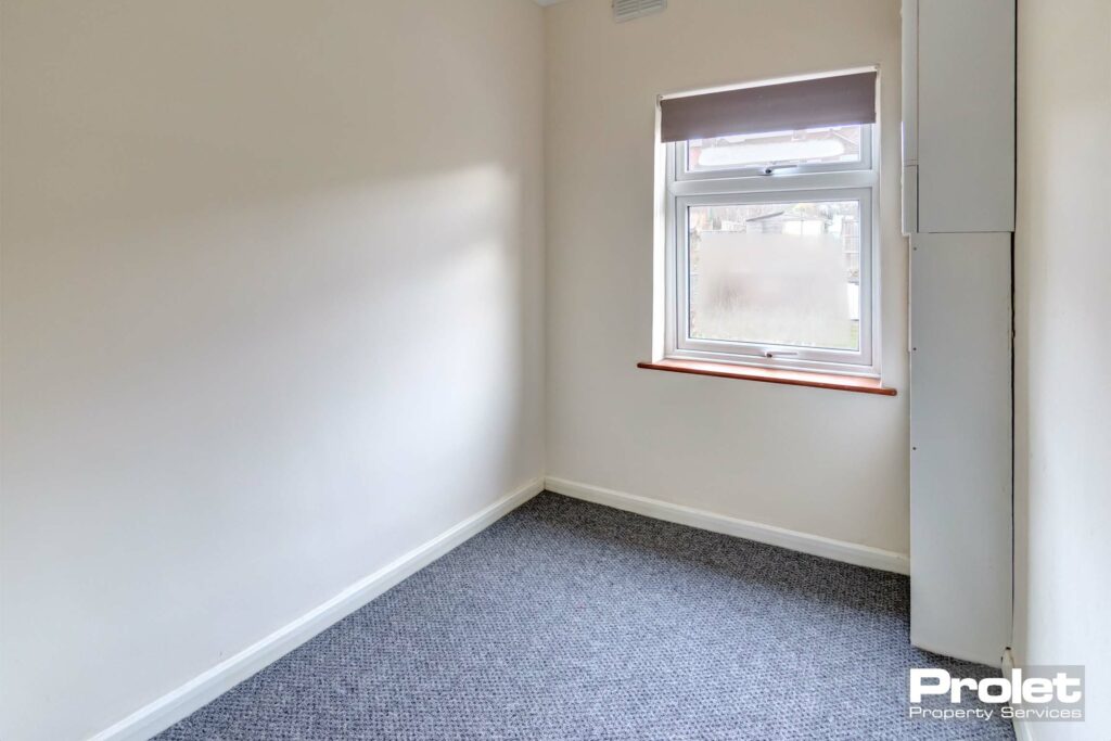 Small study space with cream walls and grey carpet.