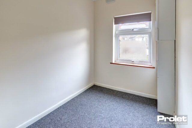 Small study space with cream walls and grey carpet.