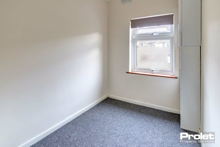 Small study space with cream walls and grey carpet.