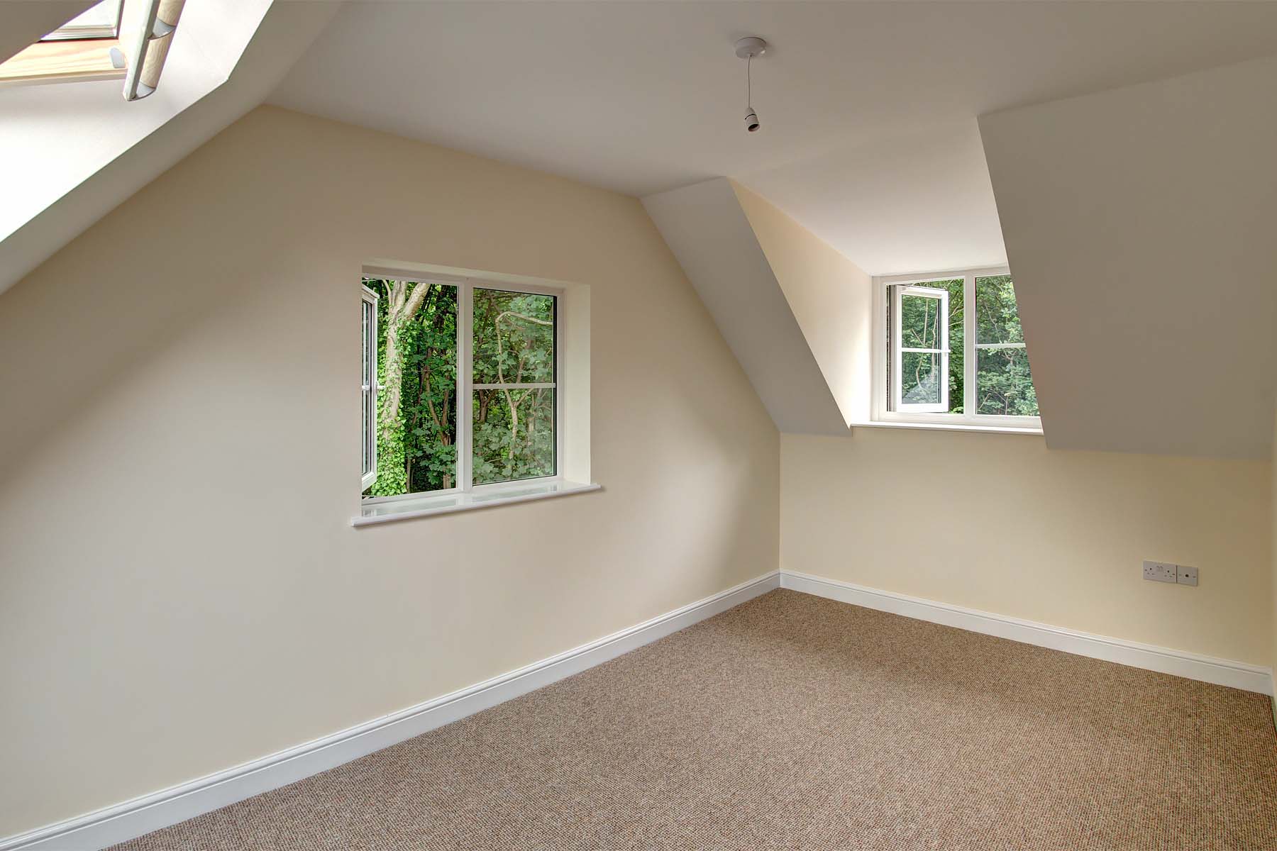 Attic bedroom with magnolia walls and beige carpet.
