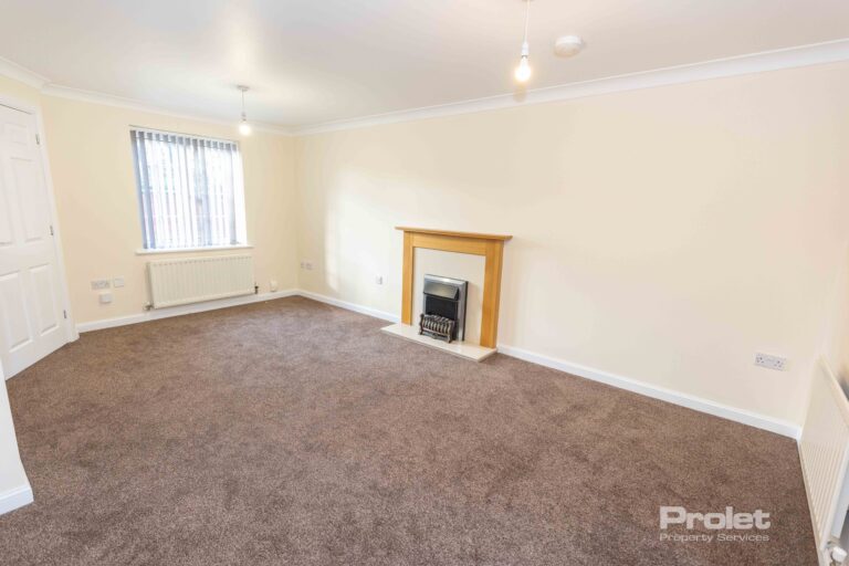 Large lounge with brown carpet, cream walls, and fireplace
