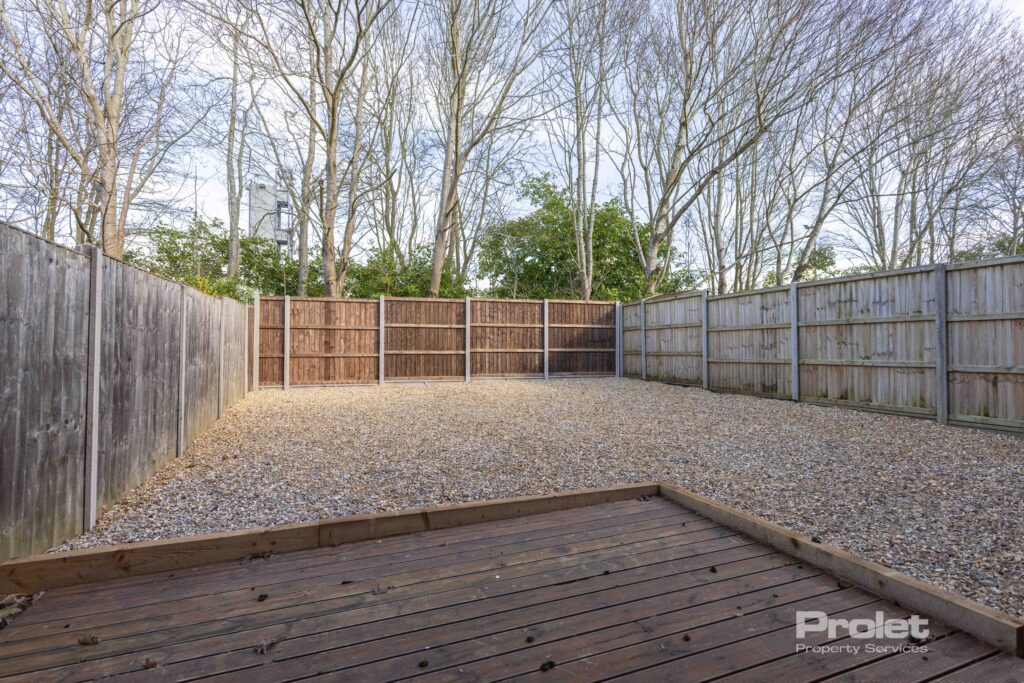 Back garden laid to shingle with decking seating area