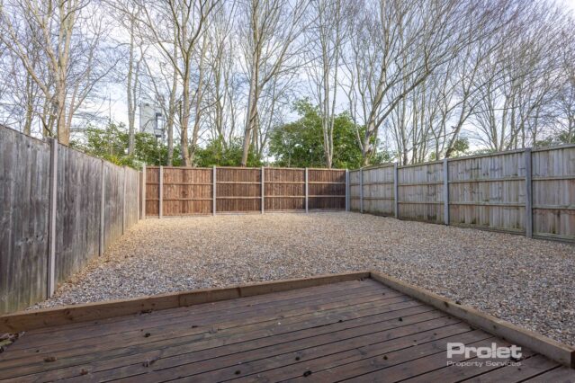 Back garden laid to shingle with decking seating area