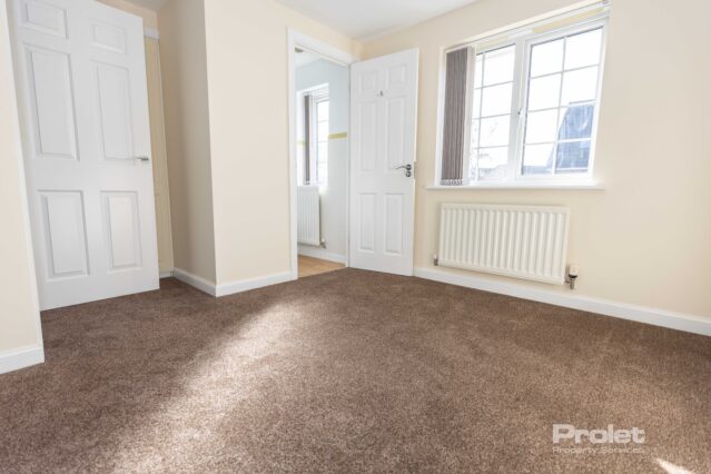 Bedroom with en-suite, brown carpet and cream walls