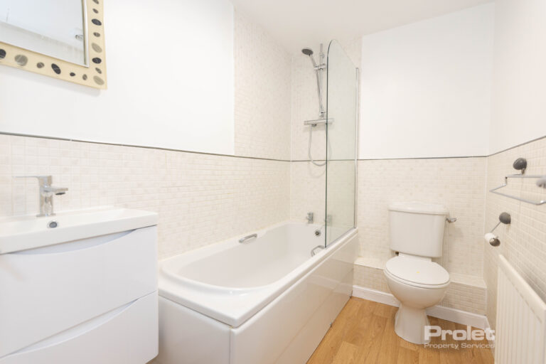 Bathroom with shower over bath, toilet, and sink