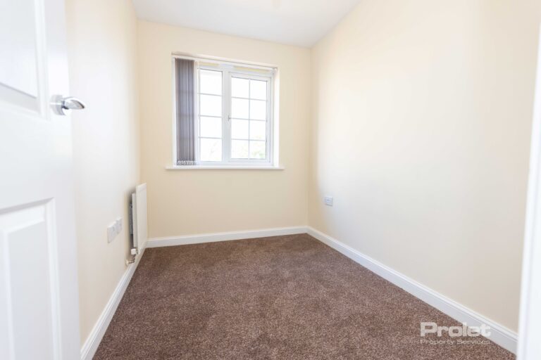 Single bedroom with cream walls and brown carpet