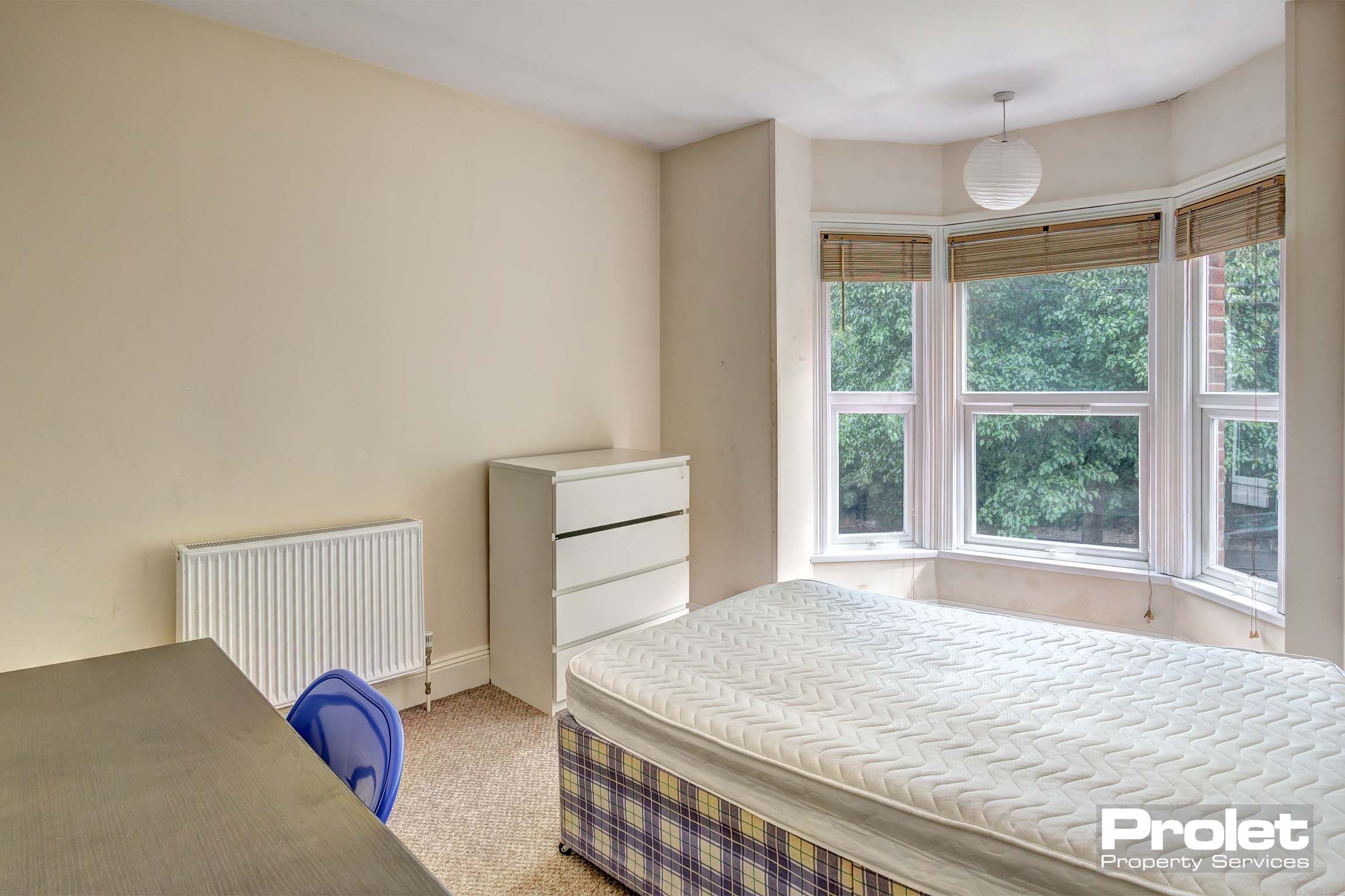 Double bed with furnishings including a desk and clothes storage